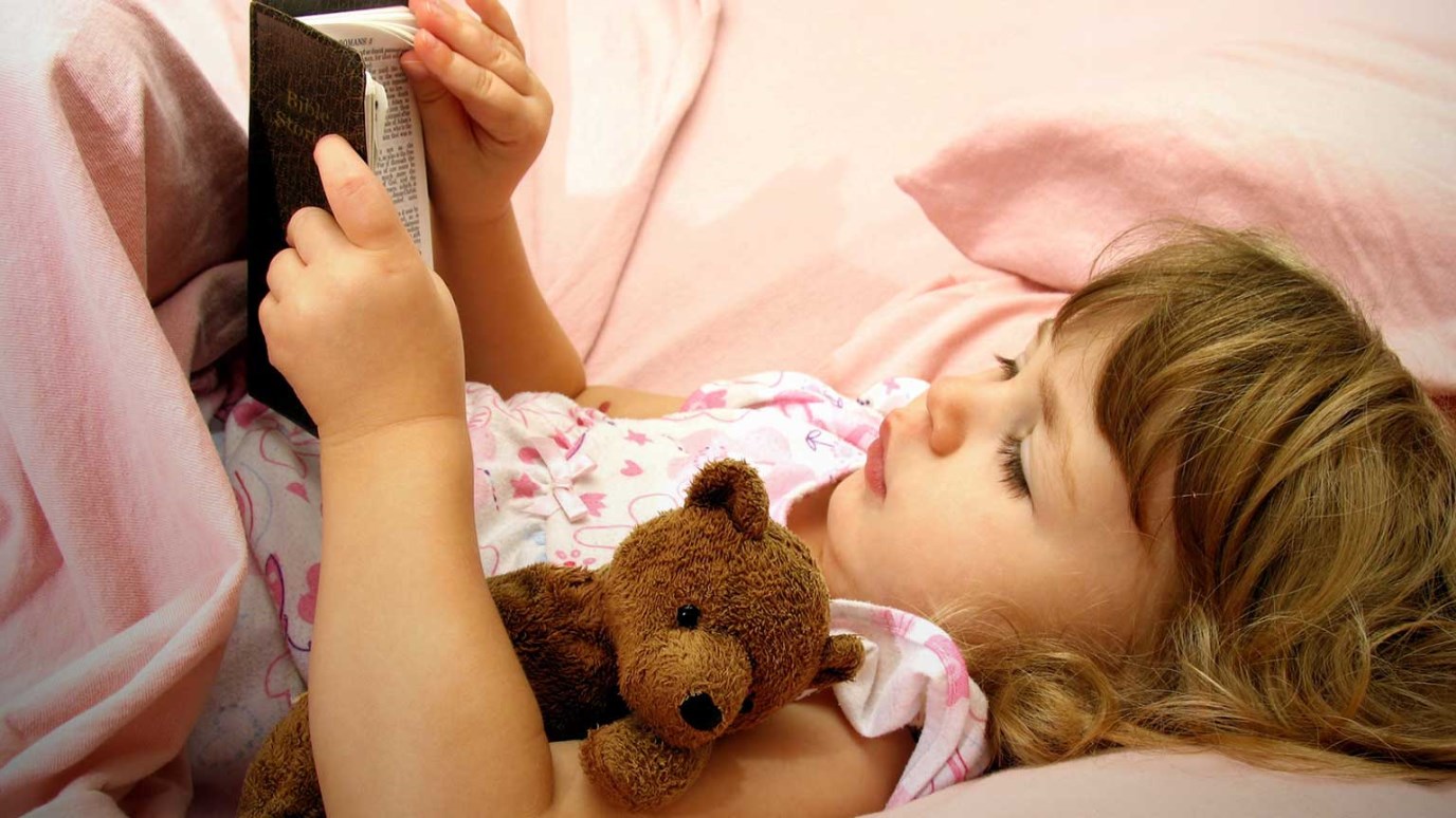 Ребенок читает в кровати